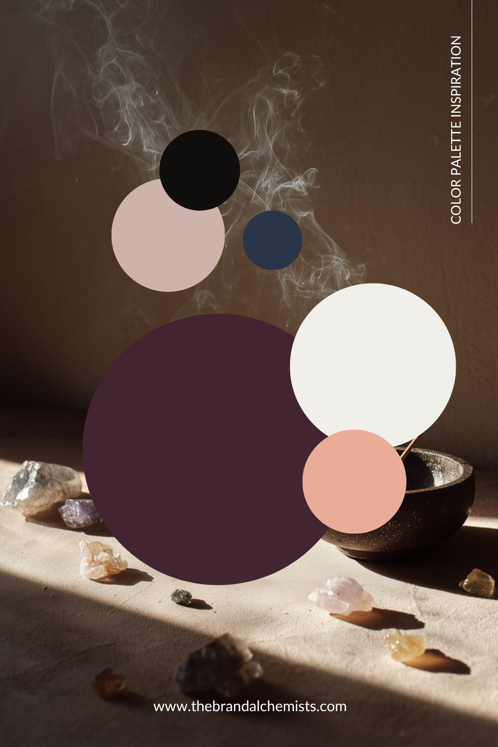 A styled color palette inspiration graphic featuring overlapping circles in black, blush pink, navy blue, white, and deep plum over a moody brown background with crystals and a bowl on a surface. Text reads 'COLOR PALETTE INSPIRATION' and 'www.